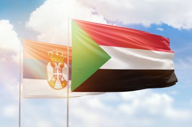 Sunny blue sky and flags of sudan and serbia
