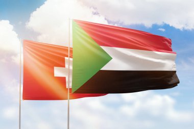 Sunny blue sky and flags of sudan and switzerland