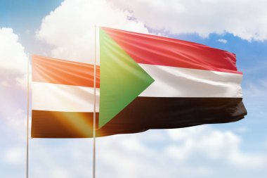 Sunny blue sky and flags of sudan and yemen