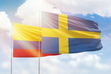Sunny blue sky and flags of sweden and colombia