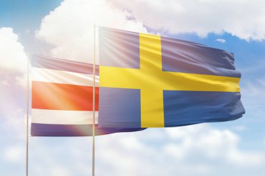 Sunny blue sky and flags of sweden and costa rica