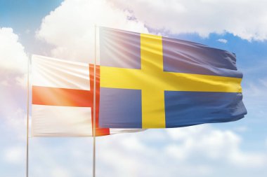 Sunny blue sky and flags of sweden and england