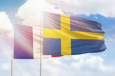 Sunny blue sky and flags of sweden and france