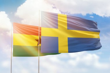Sunny blue sky and flags of sweden and ghana