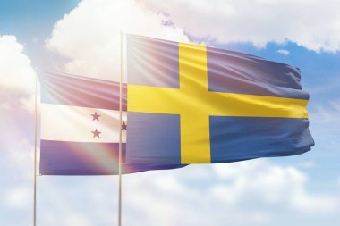 Sunny blue sky and flags of sweden and honduras