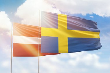 Sunny blue sky and flags of sweden and latvia