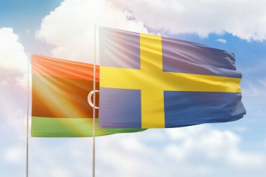 Sunny blue sky and flags of sweden and libya