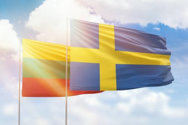 Sunny blue sky and flags of sweden and lithuania