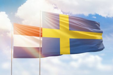 Sunny blue sky and flags of sweden and netherlands