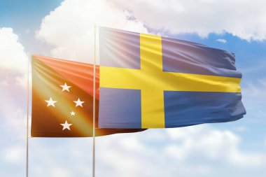 Sunny blue sky and flags of sweden and papua new guinea