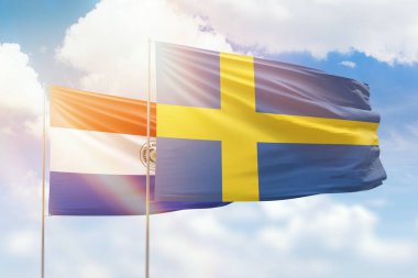 Sunny blue sky and flags of sweden and paraguay