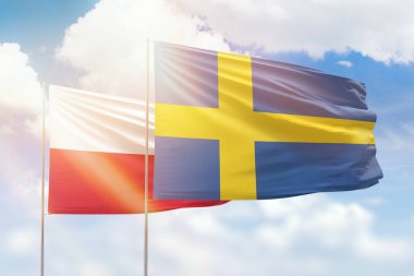 Sunny blue sky and flags of sweden and poland