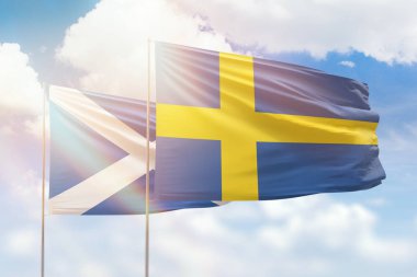 Sunny blue sky and flags of sweden and scotland