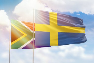 Sunny blue sky and flags of sweden and south africa