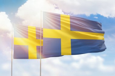 Sunny blue sky and flags of sweden and sweden