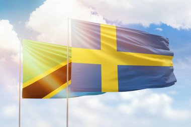 Sunny blue sky and flags of sweden and tanzania