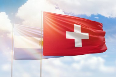 Sunny blue sky and flags of switzerland and argentina