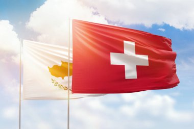 Sunny blue sky and flags of switzerland and cyprus