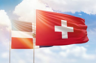 Sunny blue sky and flags of switzerland and dominican republic