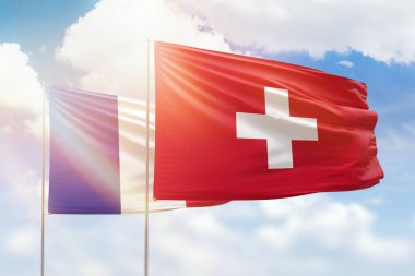 Sunny blue sky and flags of switzerland and france