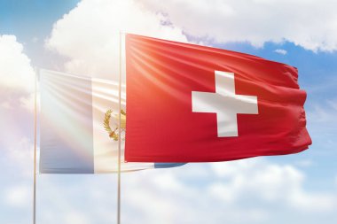 Sunny blue sky and flags of switzerland and guatemala