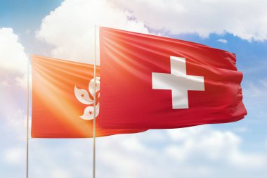 Sunny blue sky and flags of switzerland and hong kong