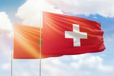 Sunny blue sky and flags of switzerland and morocco