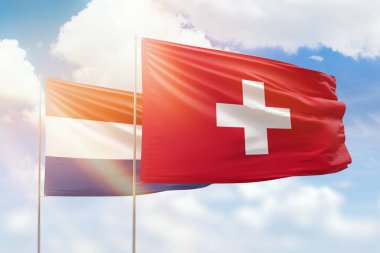 Sunny blue sky and flags of switzerland and netherlands