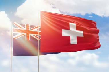 Sunny blue sky and flags of switzerland and new zealand