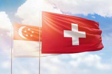 Sunny blue sky and flags of switzerland and singapore