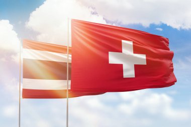 Sunny blue sky and flags of switzerland and thailand