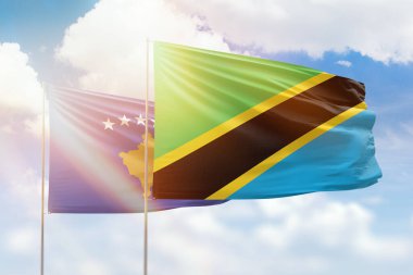 Sunny blue sky and flags of tanzania and kosovo