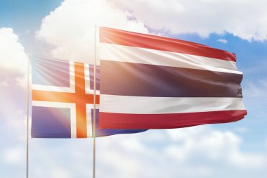 Sunny blue sky and flags of thailand and iceland