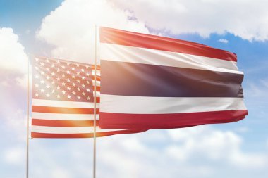 Sunny blue sky and flags of thailand and usa