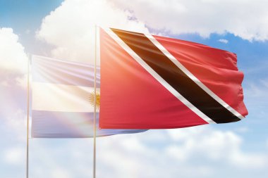Sunny blue sky and flags of trinidad and tobago and argentina