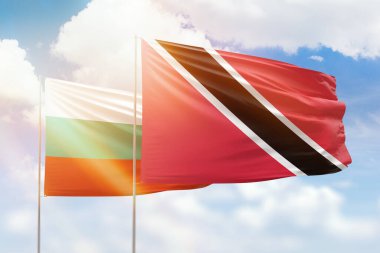 Sunny blue sky and flags of trinidad and tobago and bulgaria