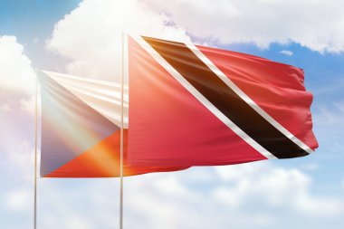 Sunny blue sky and flags of trinidad and tobago and czechia