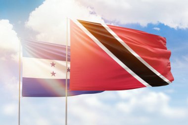 Sunny blue sky and flags of trinidad and tobago and honduras