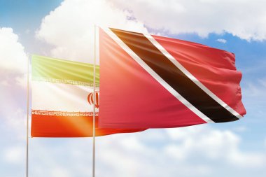 Sunny blue sky and flags of trinidad and tobago and iran