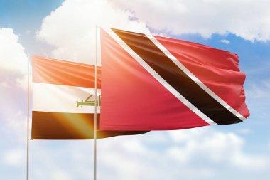 Sunny blue sky and flags of trinidad and tobago and iraq