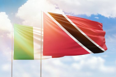 Sunny blue sky and flags of trinidad and tobago and italy