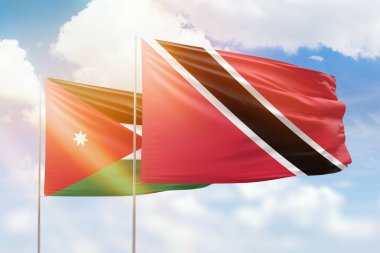 Sunny blue sky and flags of trinidad and tobago and jordan