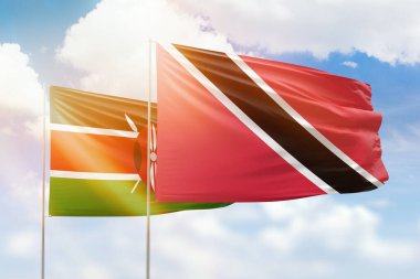 Sunny blue sky and flags of trinidad and tobago and kenya