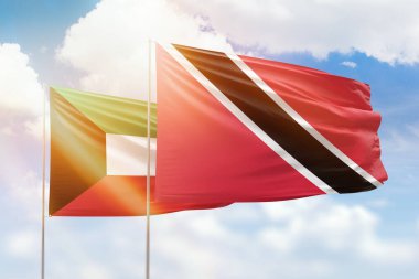 Sunny blue sky and flags of trinidad and tobago and kuwait