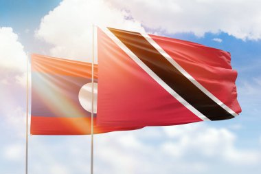 Sunny blue sky and flags of trinidad and tobago and laos