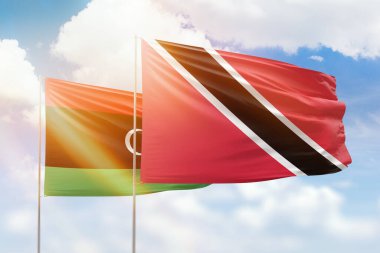 Sunny blue sky and flags of trinidad and tobago and libya