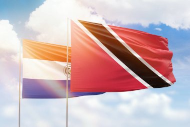 Sunny blue sky and flags of trinidad and tobago and paraguay