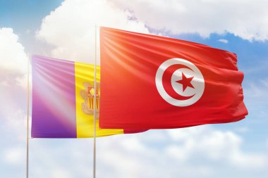 Sunny blue sky and flags of tunisia and andorra