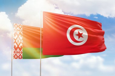 Sunny blue sky and flags of tunisia and belarus