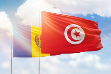 Sunny blue sky and flags of tunisia and moldova
